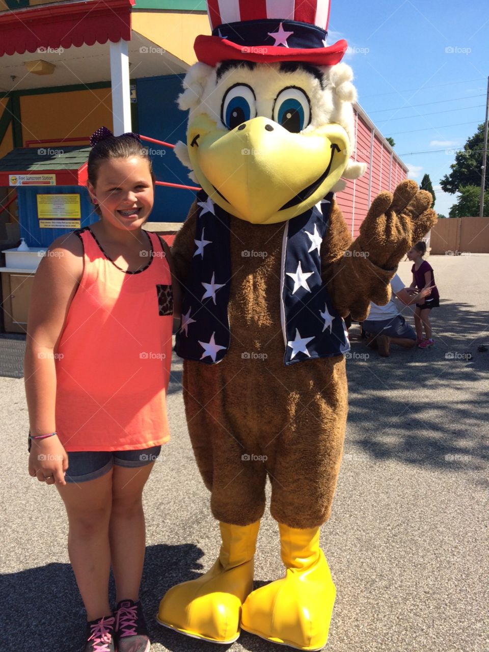 Girl standing next to patriotic eagle costume
