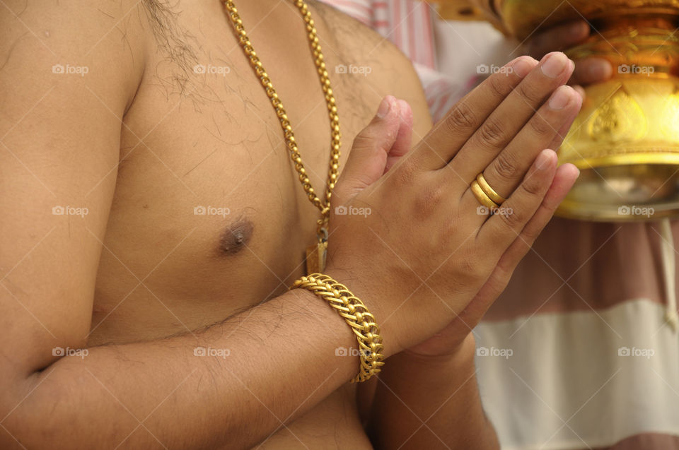 SAMUT SAKHON, THAILAND -DEC 15, 2013
Thai men do not wear a shirt, put gold, adorn the body, hold hands to worship Buddha, prepare to shave ordination.
