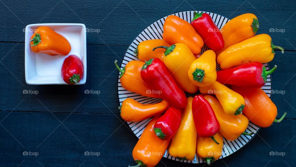 Colorful sweet peppers on a plate with a creamy dip on the side