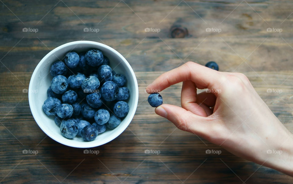 hand holding a blueberry