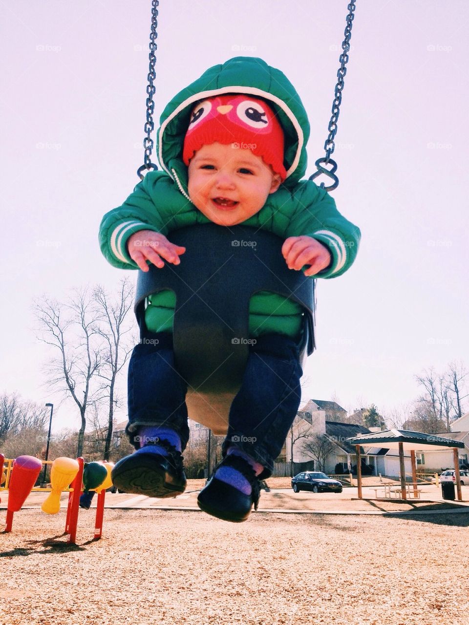 Swinging baby, winter playground