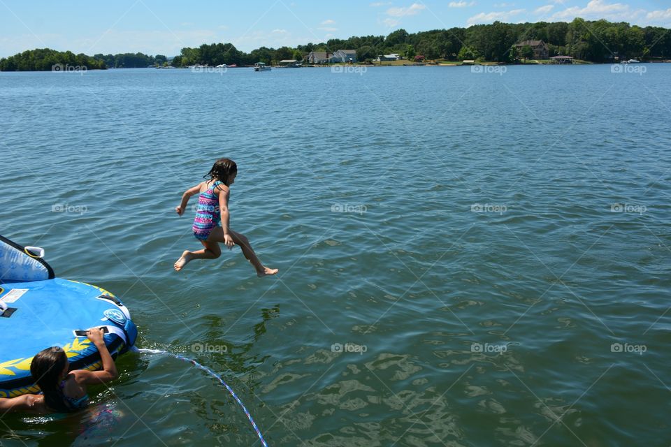 Young girl jumping into Lake captured in mid air