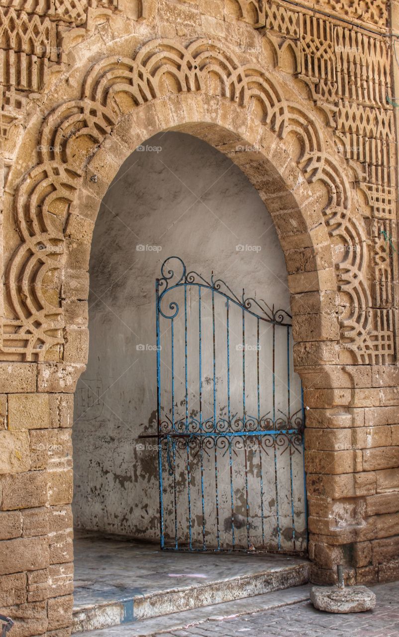 Ornate stone door way with a gate. Essaouira, Morocco 