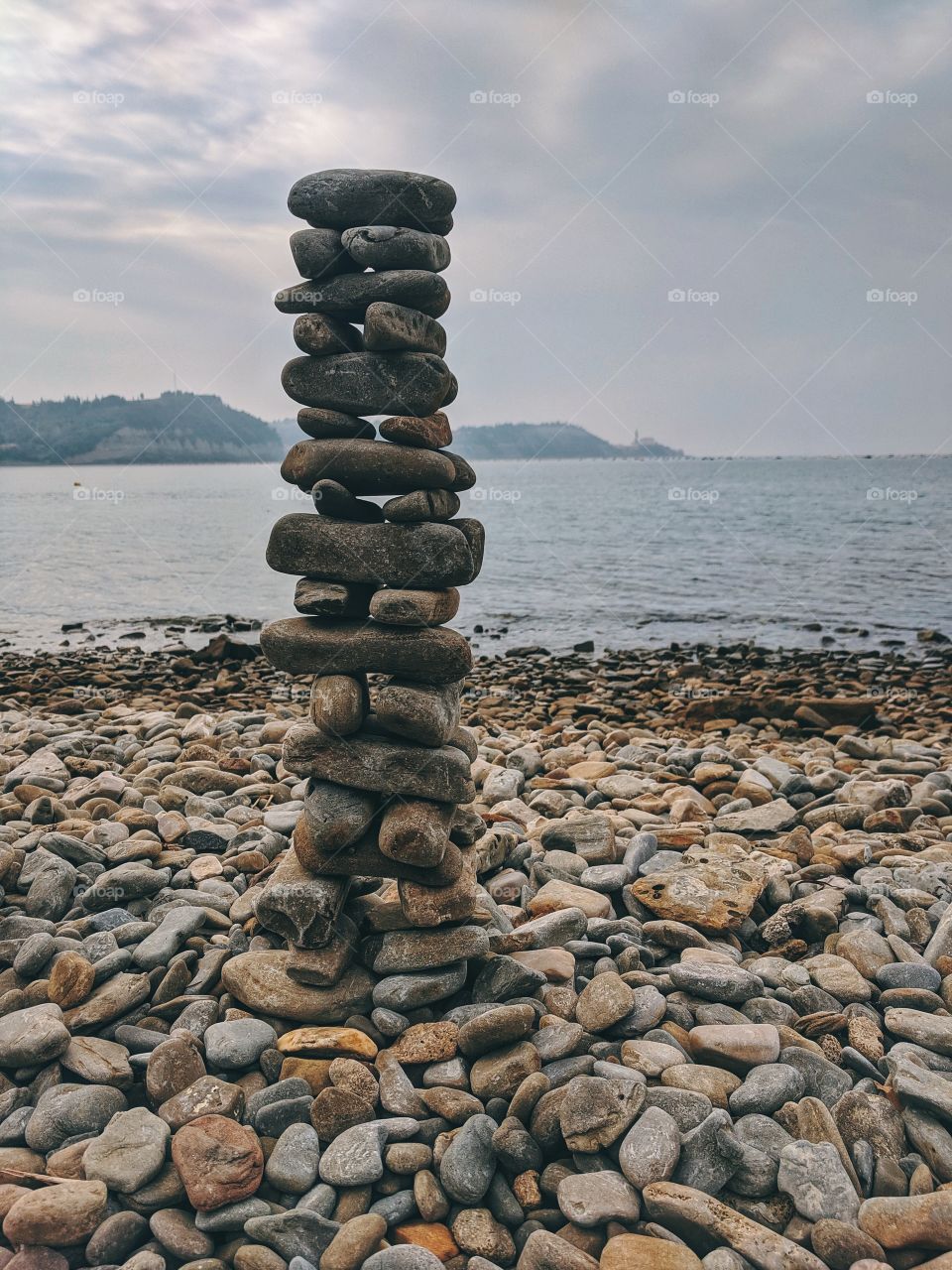 Zen. A pyramid of small stones at the seashore.