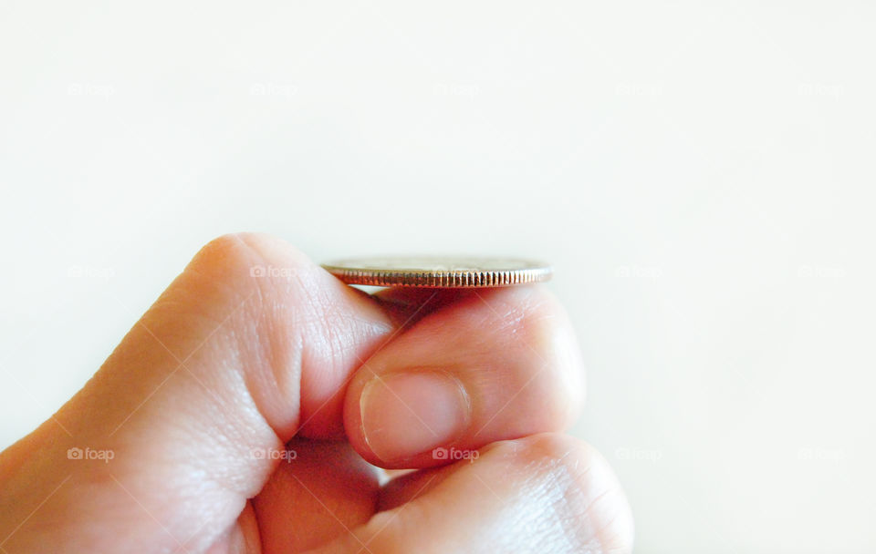 Can't decide, deciding, Toss coin, coin flip in hand, white background closeup