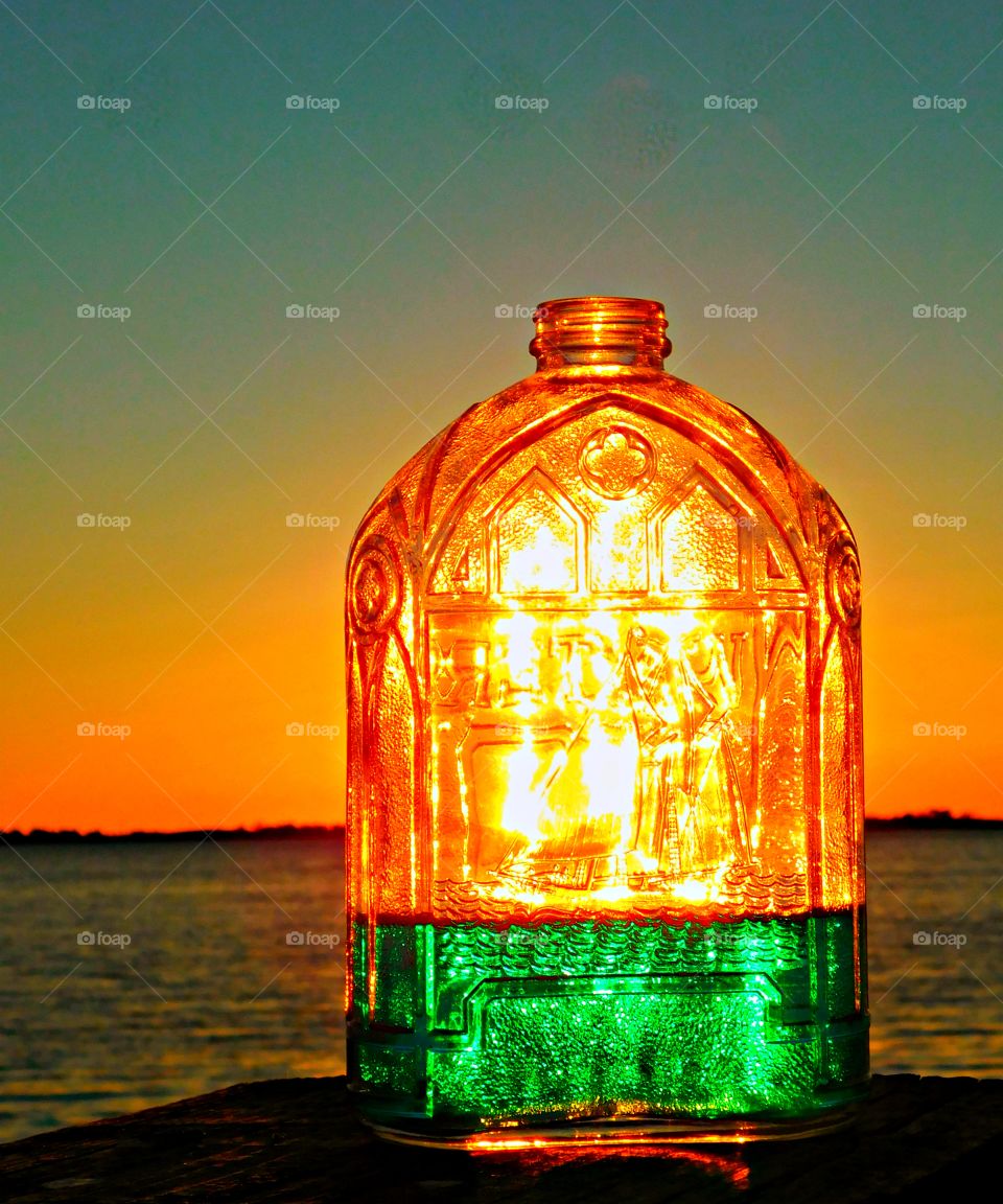 Liquids - Foap missions - A photo of a colorful bottle with green liquid sparkling in a magnificent sunset