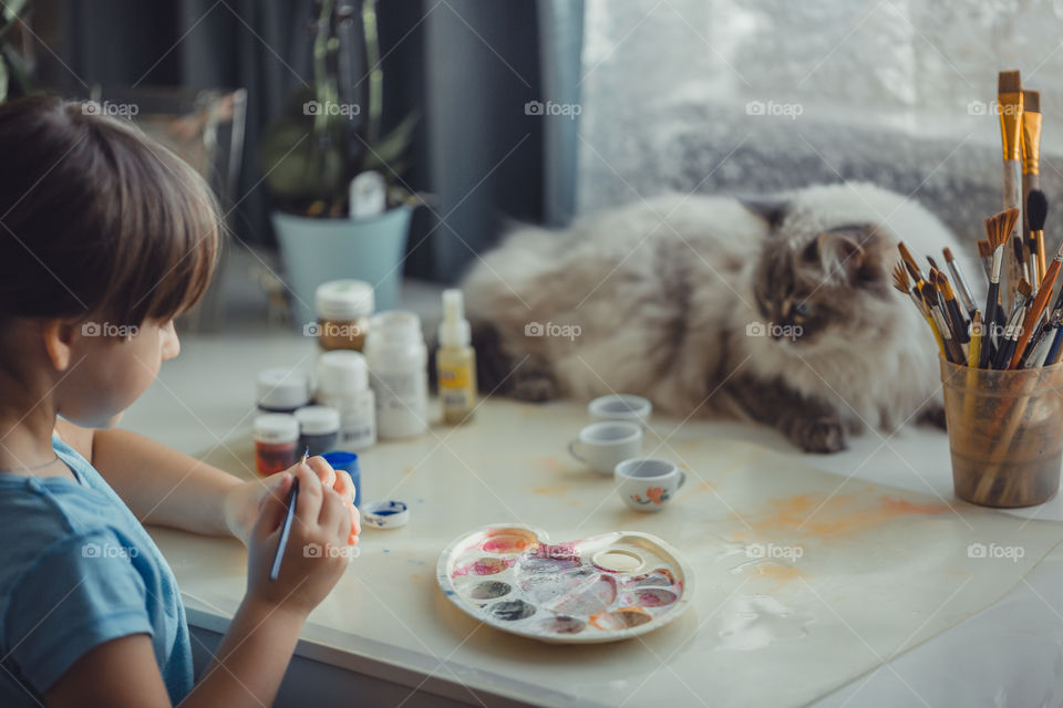 Little girl painting the Easter egg 