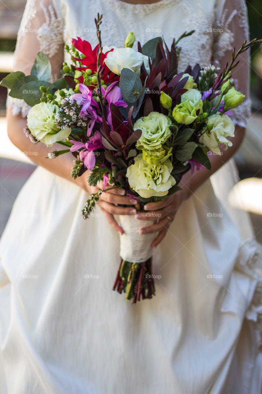 Picture of a bride grabbing her flower bouquet.