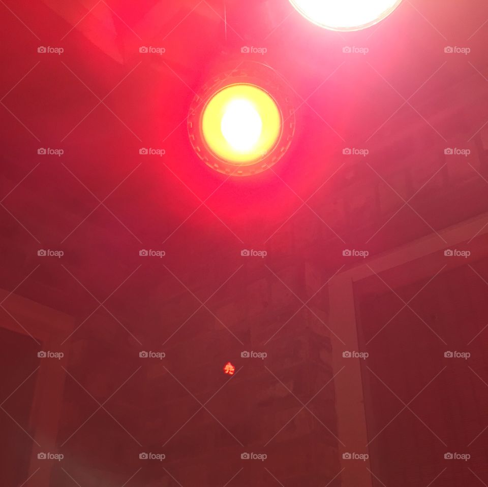 Red spotlight reflecting on brick wall.