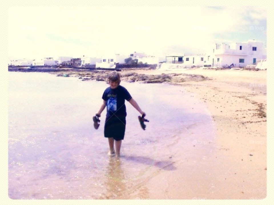 A boy walking in the sea