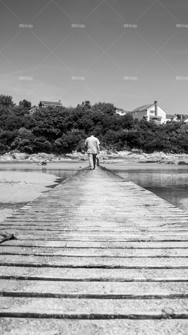 Man walking on jetty at beach