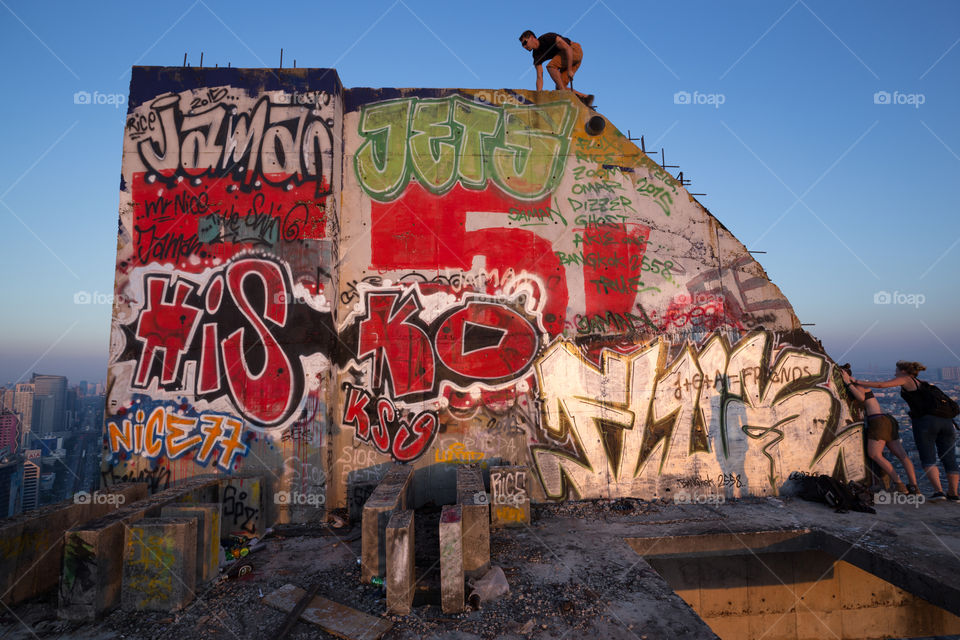 Tourist climbing on the Street art wall in the abandoned building 