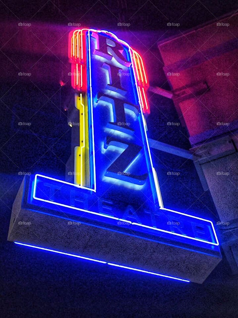 Neon Ritz sign lit up at night outside an old city theatre 