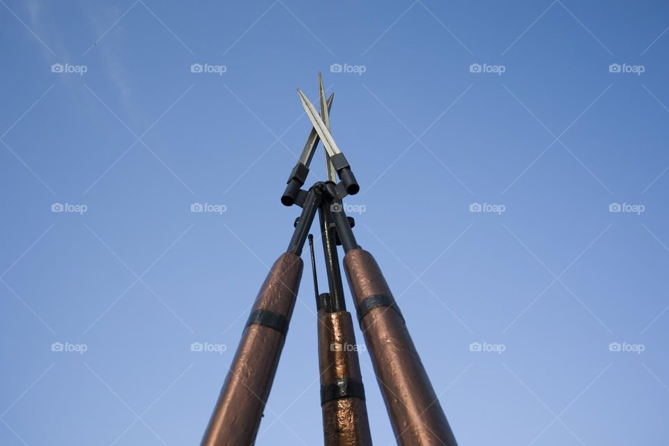 Rifle bayonets against blue sky background