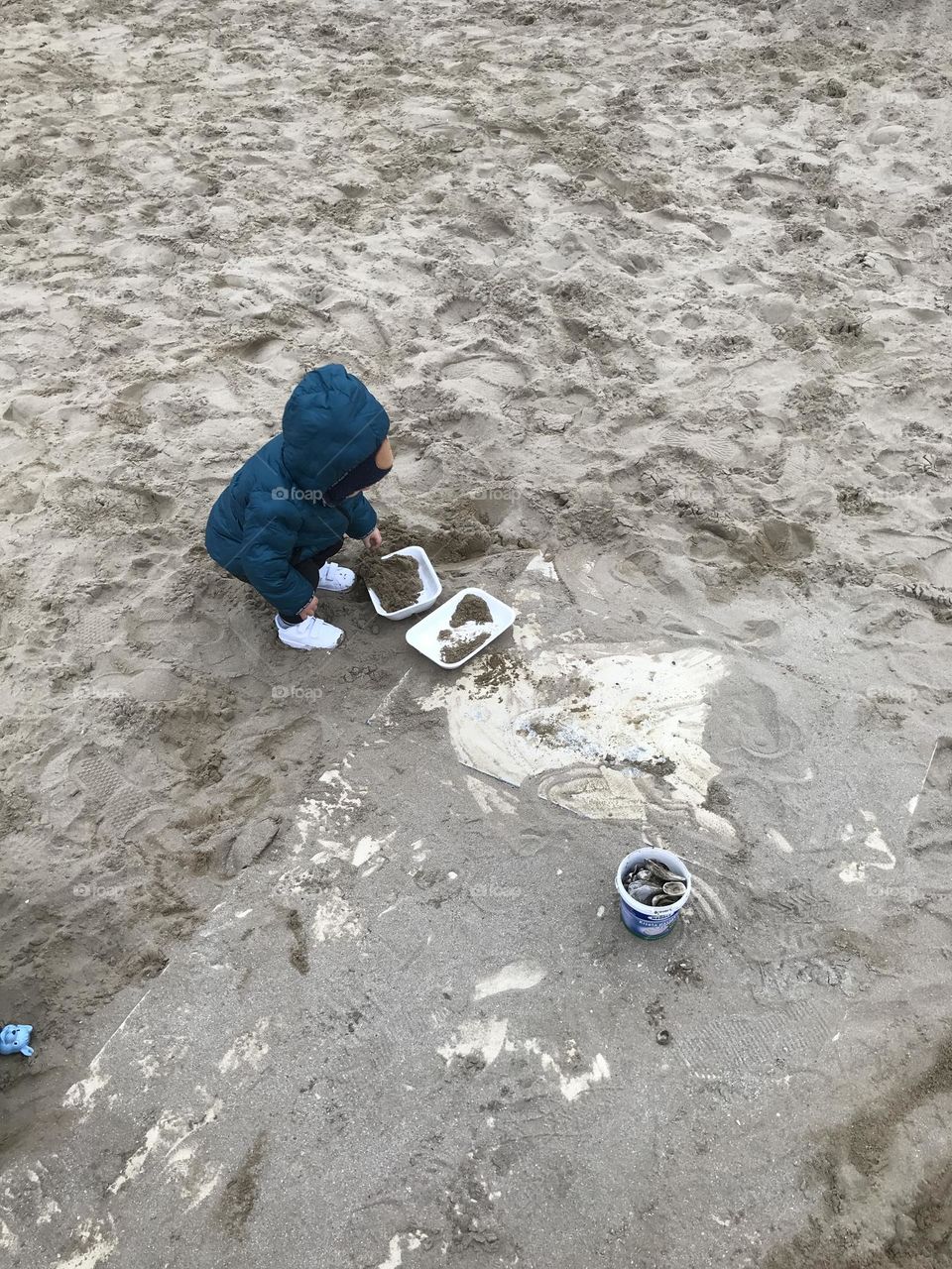 children play in the sand on the seashore in winter