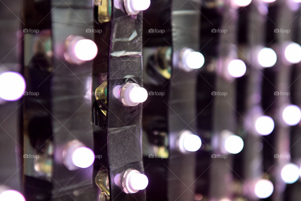 Close-up of rows of electrical strips hanging with small illuminated bulbs