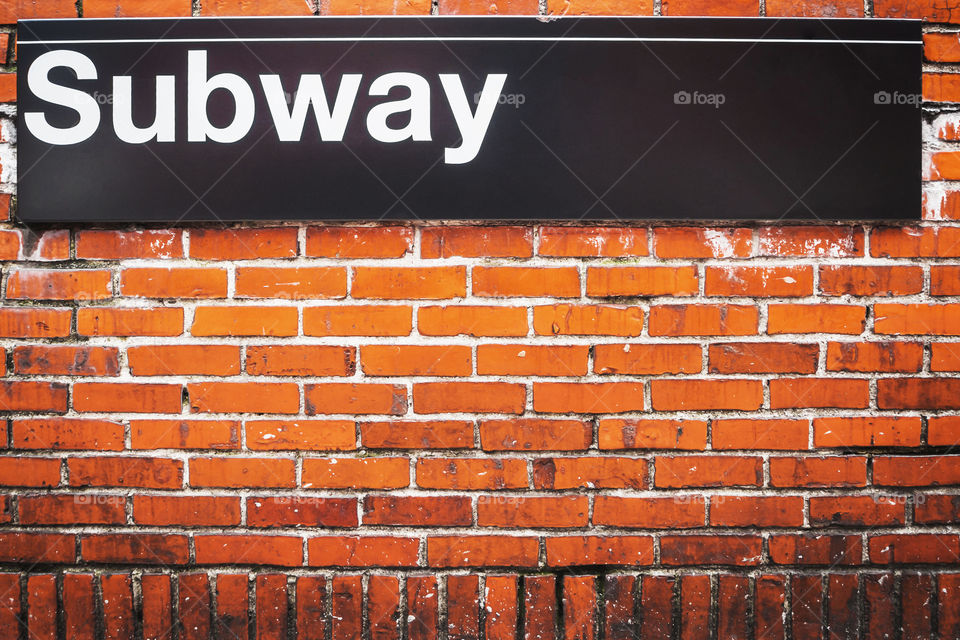 Subway sign on a red brick wall in New York 