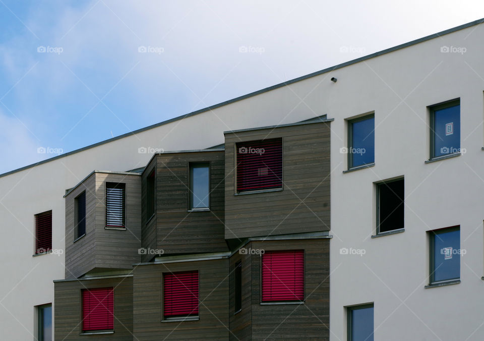 View of windows on building exterior against sky by day.