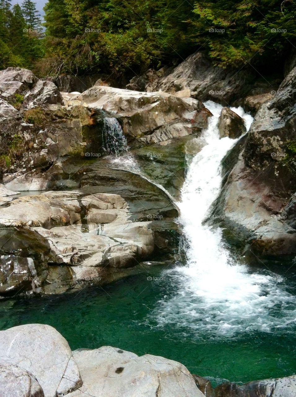 Beautiful waterfall with emerald green glacial waters