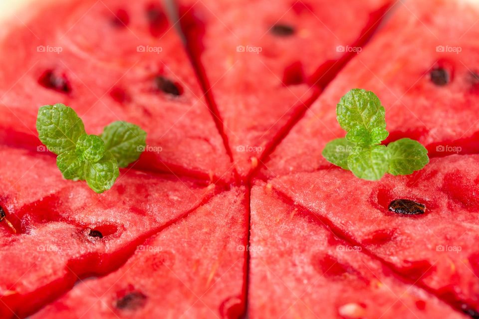 Juicy sweet watermelon slices with fresh mint leaves, summer food