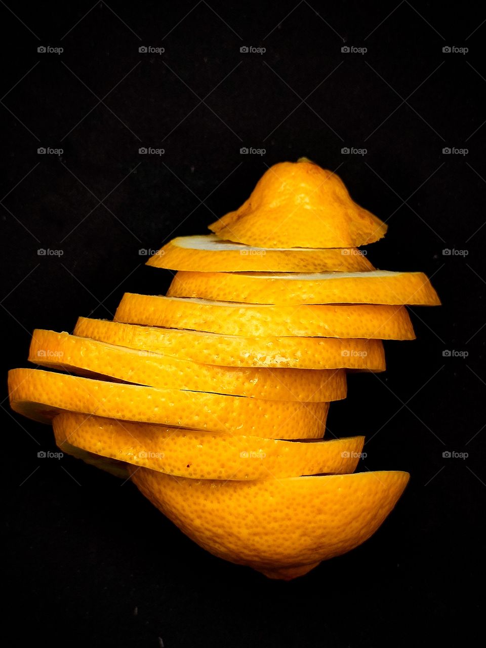 Lemon, cut into pieces.  The pieces are displaced.  Lemon on black background