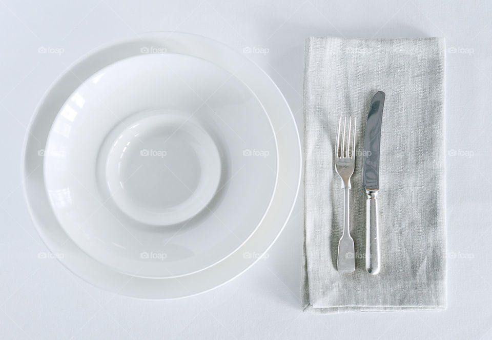 White plate and silver cutlery + linen serviette