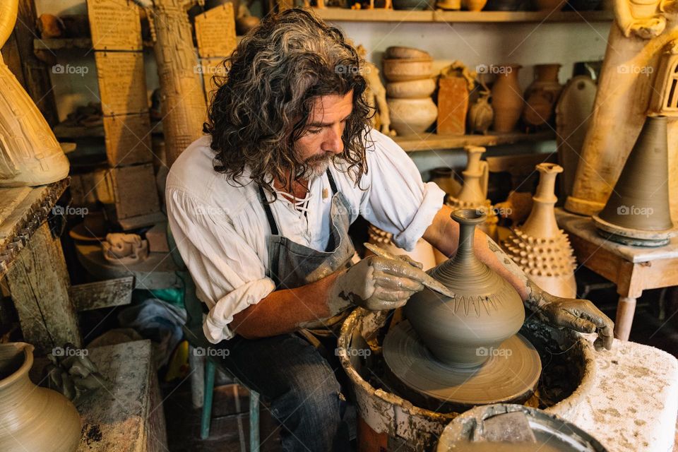 The ceramist in his studio, hand crafting a piece of art.