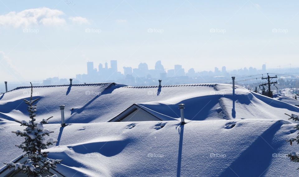 Snowy rooftops with downtown in the background