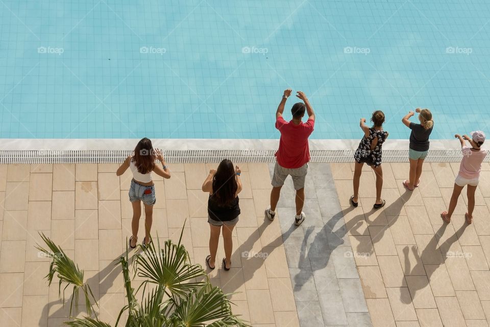 A group of young people dancing by the pool