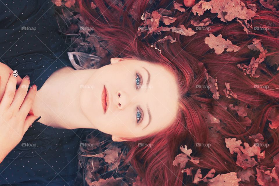 Close-up of a woman lying on dry leaves