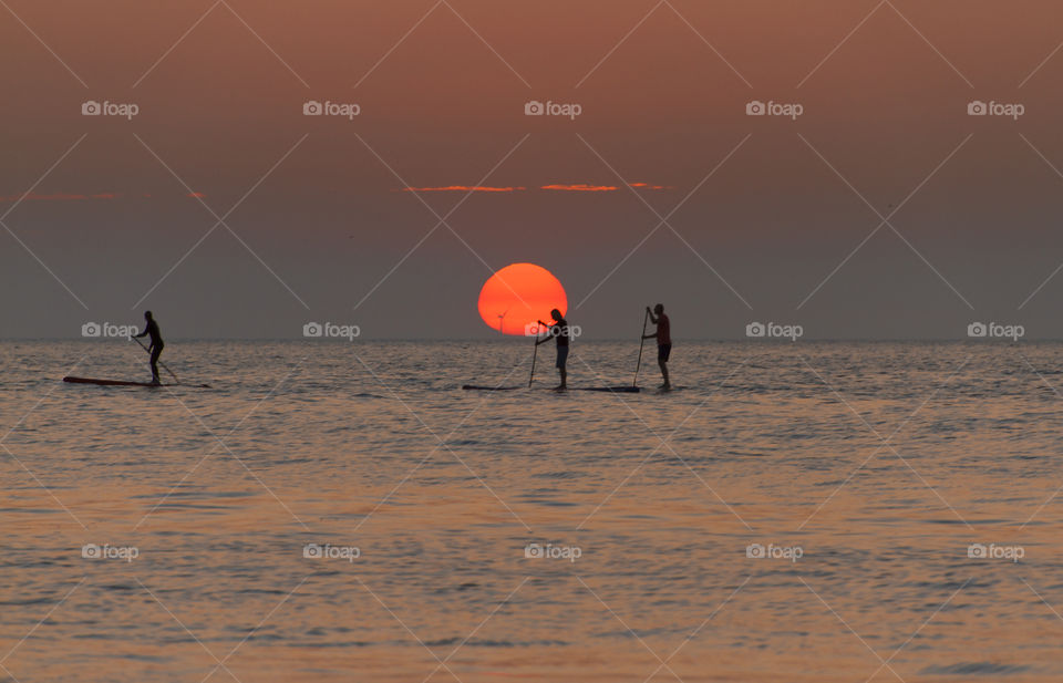 Paddle boarding round sunset