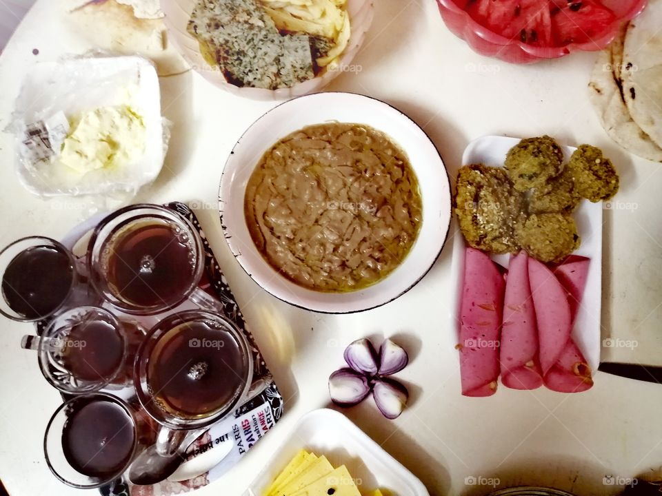 A popular Egyptian breakfast made of Egyptian beans, peppers, omelets, French fries, cheese, bread, anchoons and watermelon