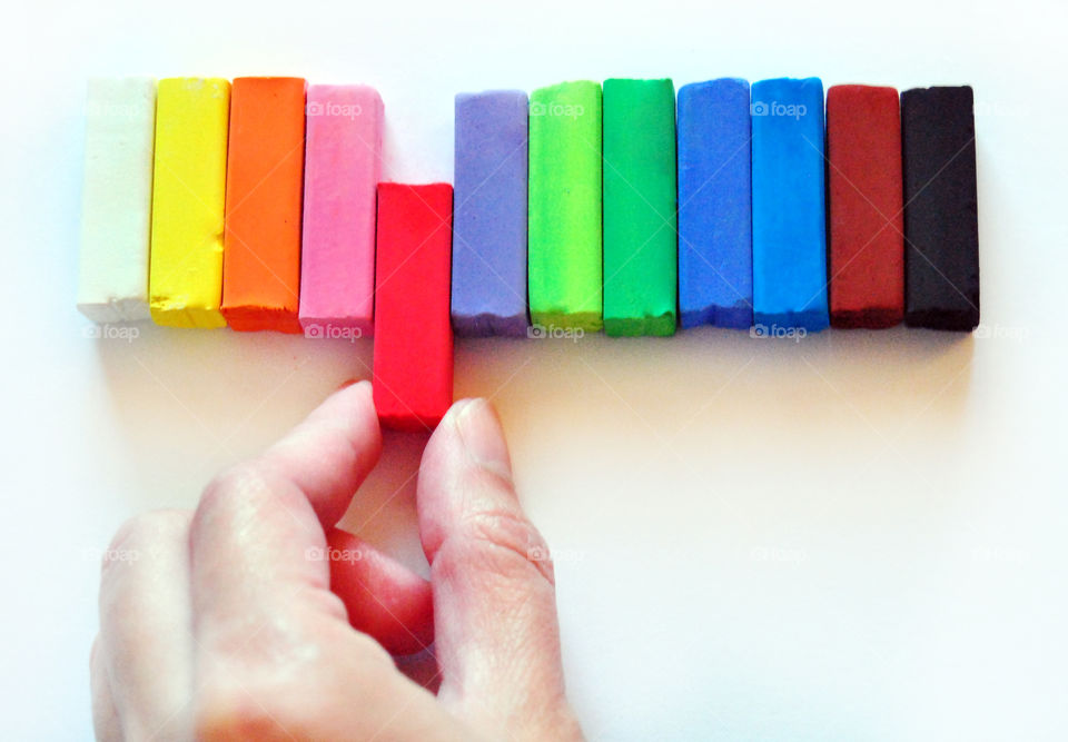 Making decisions, which chalk color, too view, closeup, hands holding red chalk