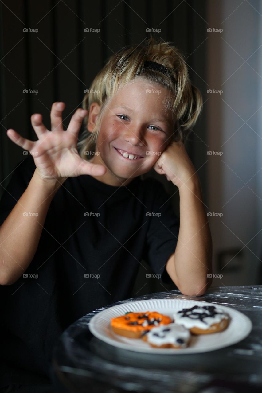 A seven year old child makes handmade cookies for Halloween.