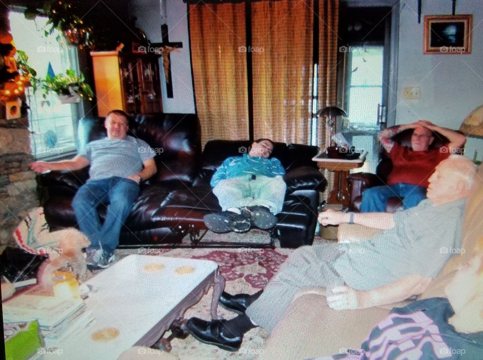 Man napping in recliner couch after big family dinner. Time to watch a game on TV.