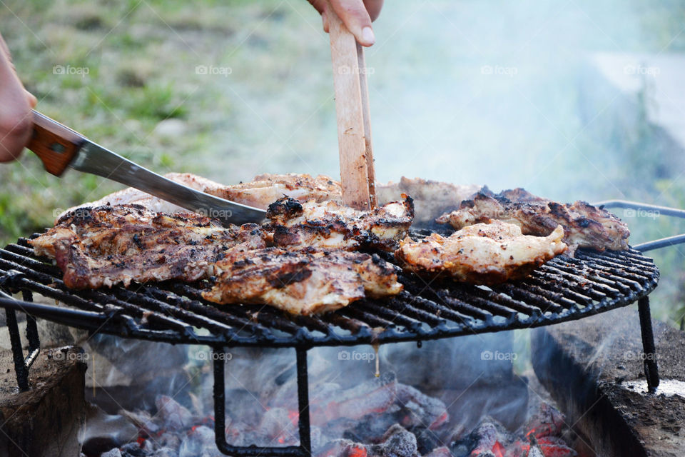 grilled meat on bbq. male hands preparing meat for grill