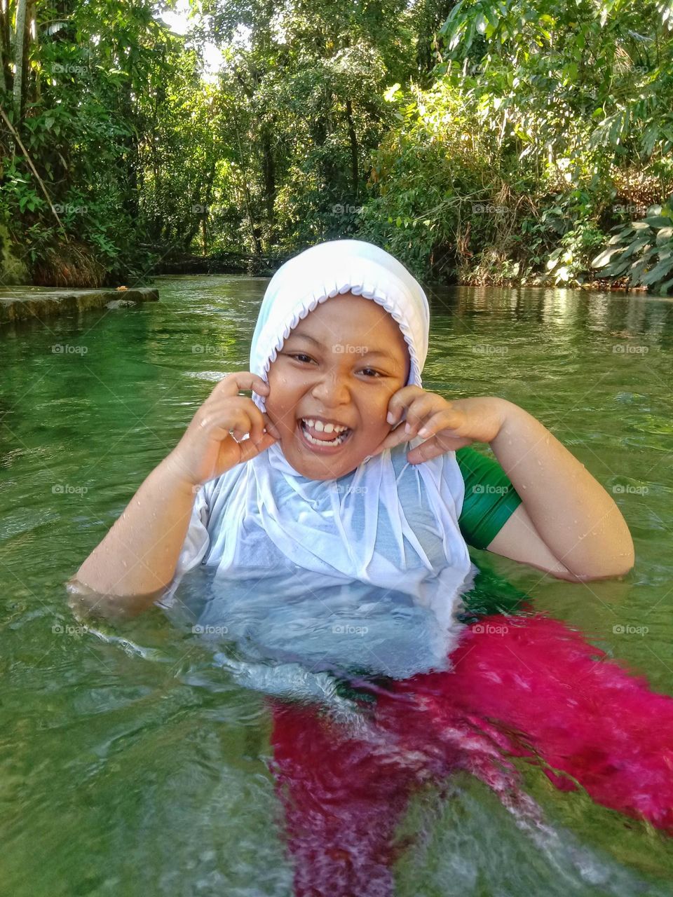 The little girl is happy when playing in the river.