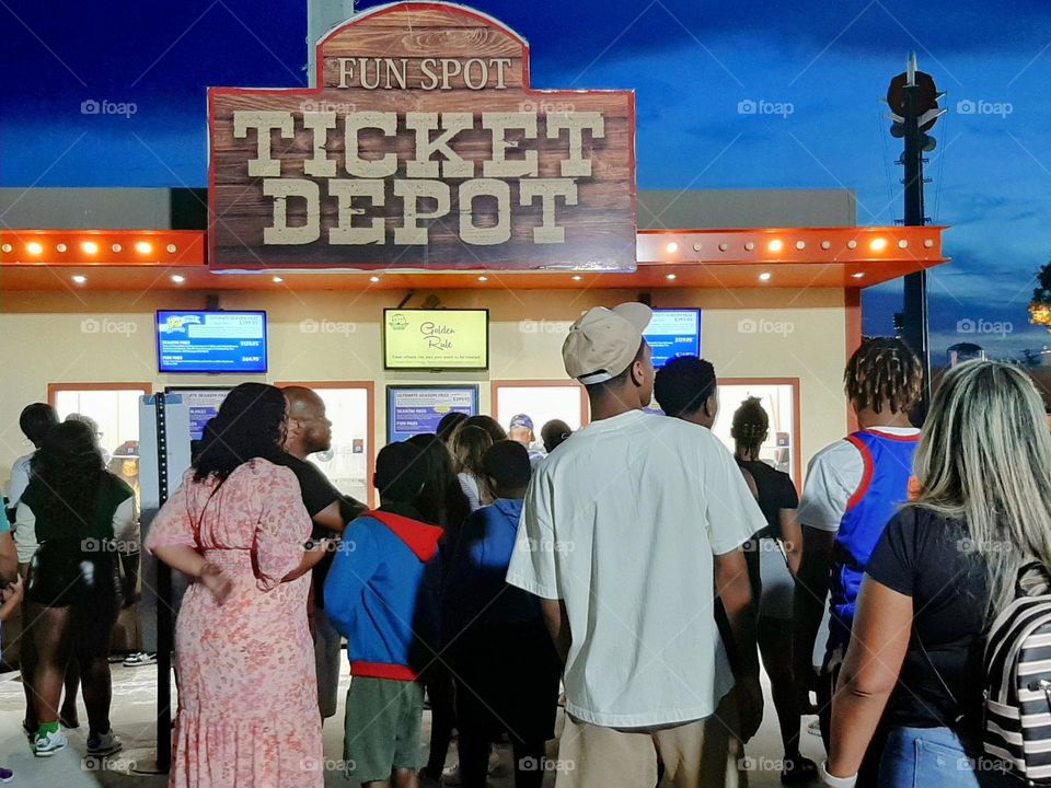 At the ticket box to buy tickets for a night of fun rides at the amusement park.