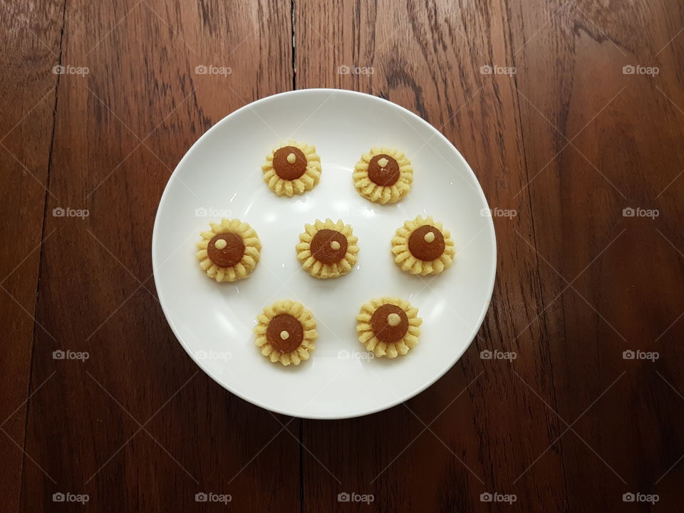 Pretty homemade yellow pineapple tarts pastry arranged in shape of sunflower