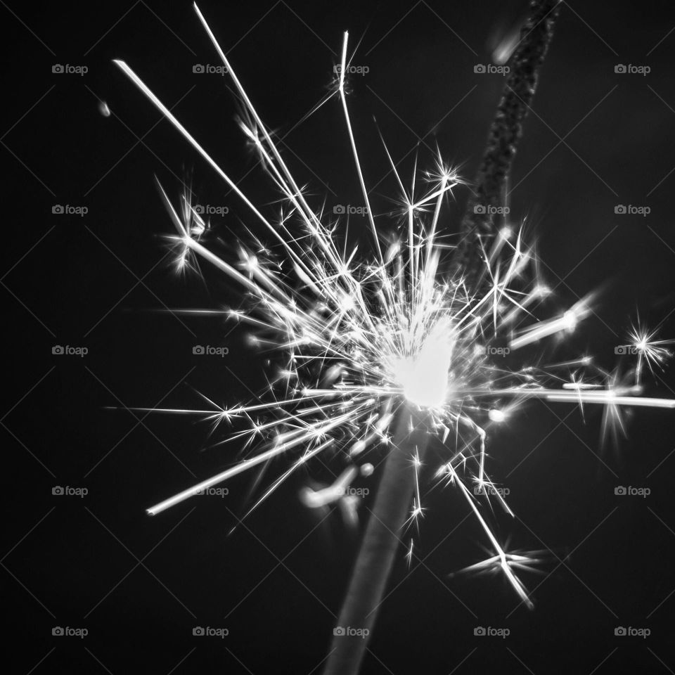 A lit sparkler in black & white