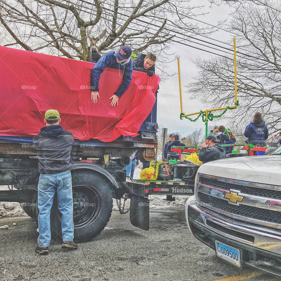 Group of people placing sheet on truck