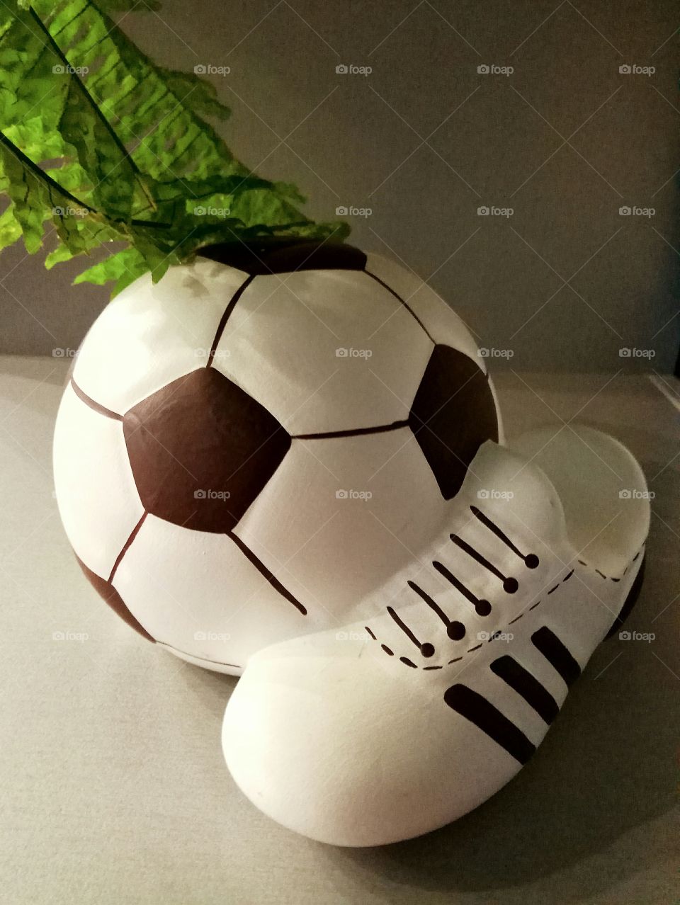 piggy bank in the form of a ball and a boot on a gray background
