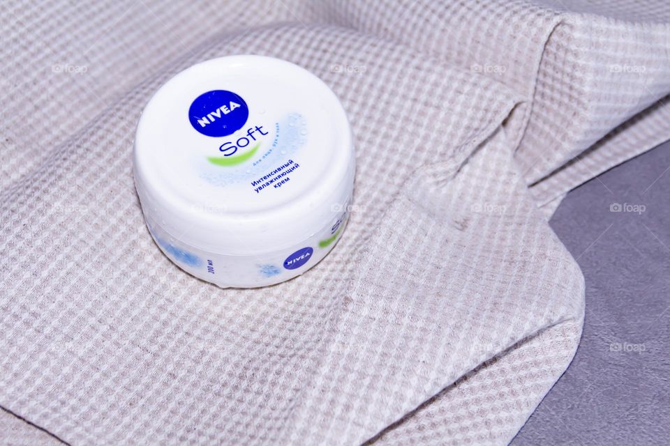 Cosmetic product, Nivea skin care cream on gray surface and linen napkin