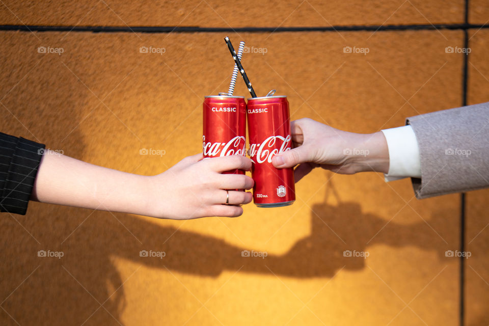 Two Coca-Cola cans with paper sticks. Cheers