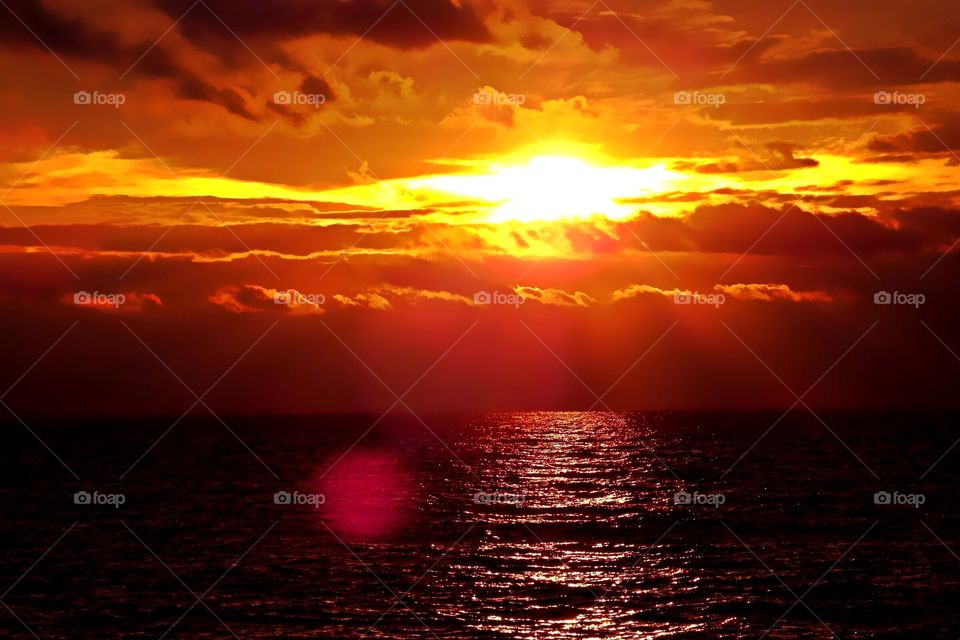 Gold and red fiery sunset over the ocean.