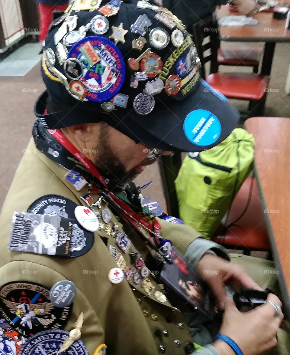 Proud Veteran wearing his hobby of collecting pins,  patches and buttons.
