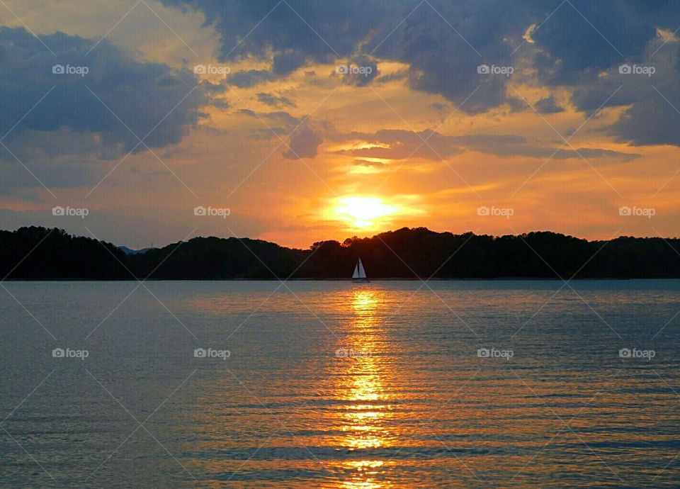 sunset over lake,  sailboat