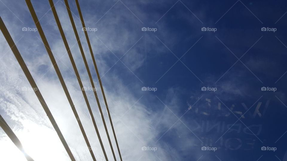 The beams of the Sunshine Skyway Bridge reach high into the cloudy blue sky.