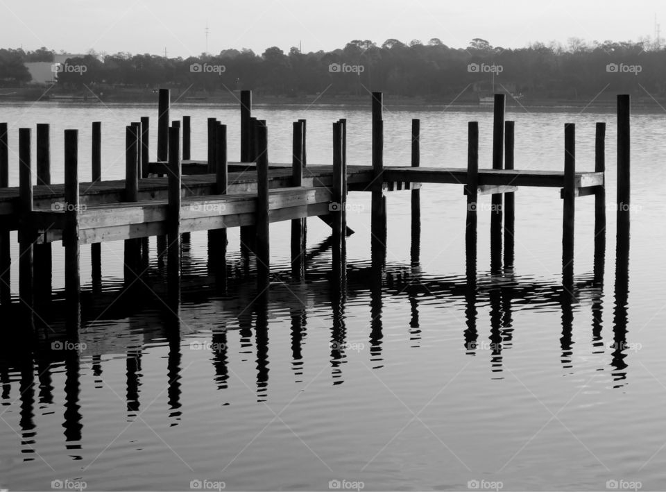 Wooden dock in the shimmering water of the bay!
Reflection of the rustic wooden dock on the bay water!