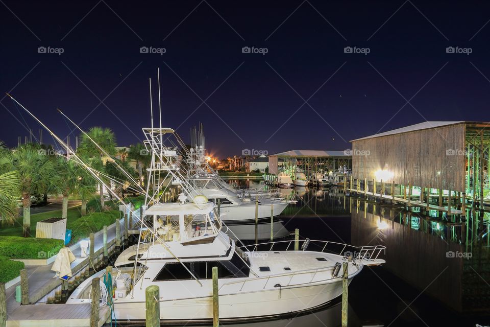 Parking boat at sea port dock at night time with yacht